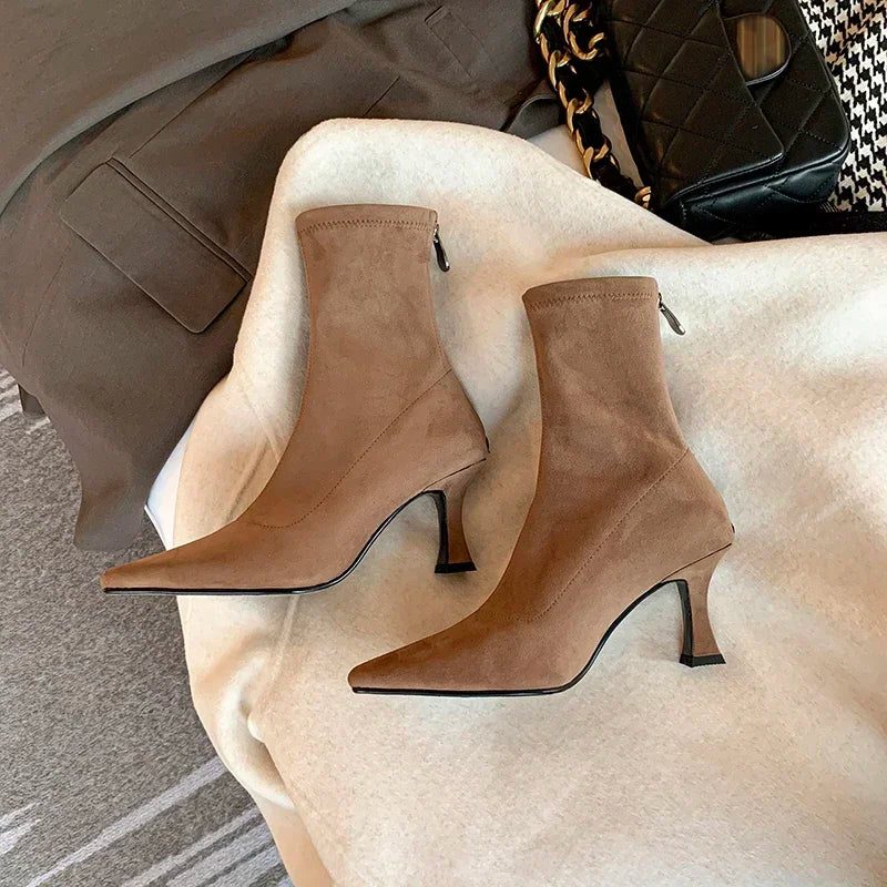 Ankle boots with a block heel and pointed toe, product still life