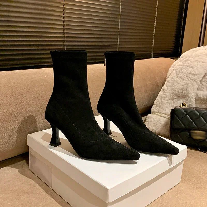 Ankle boots with a block heel and pointed toe, product still life