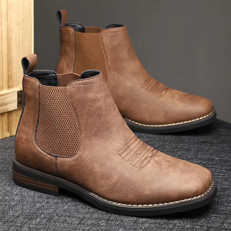Men's leather Chelsea boots with elastic side panel, product still life