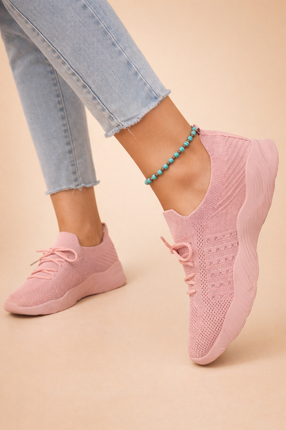 Women's red slip-on knit trainers with a cushioned rubber sole