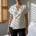 Women's white wrap blouse with cap sleeves and a soft asymmetric drape