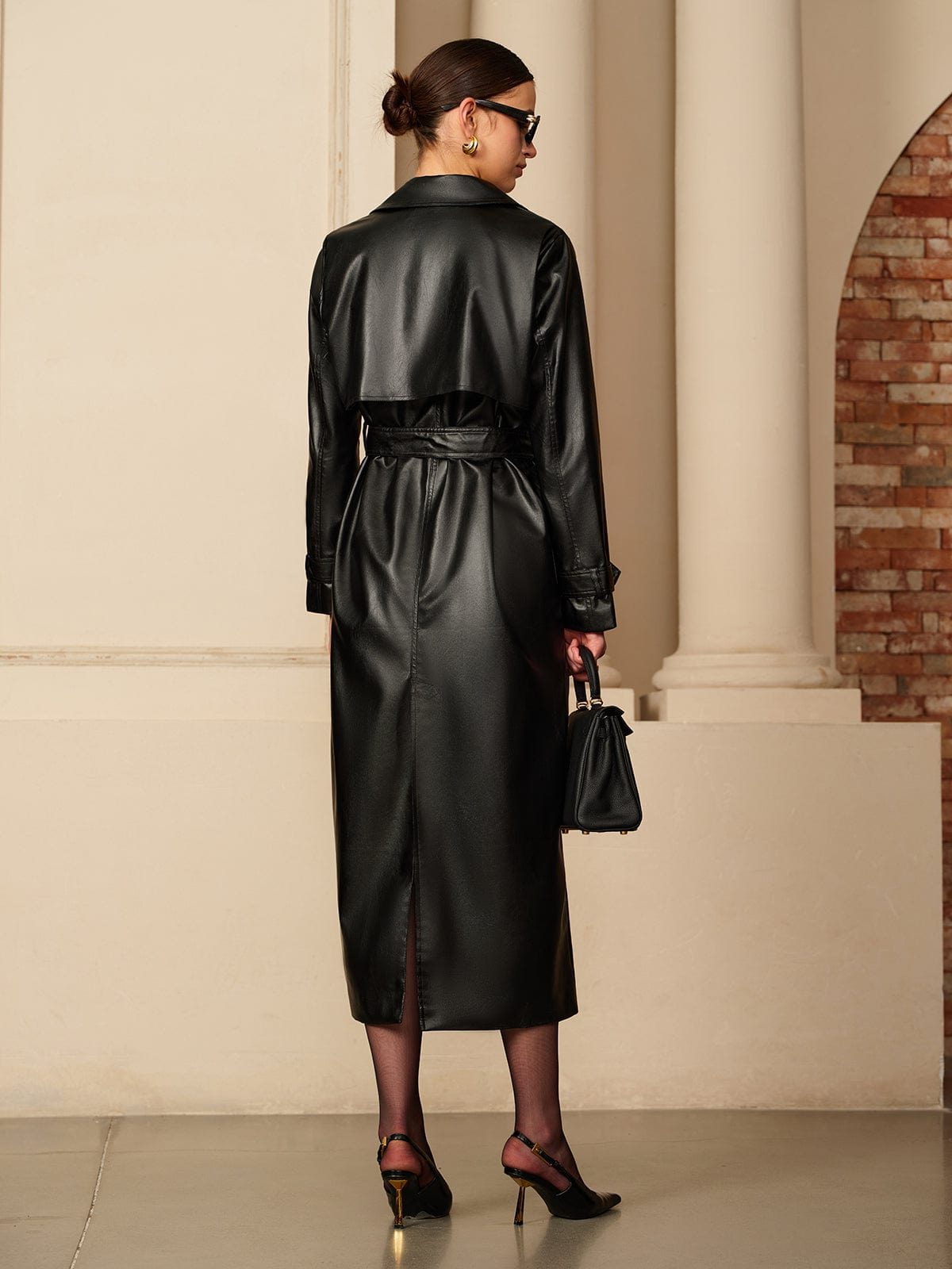 Close-up of belt detail on black faux leather trench coat