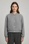 Cropped jacket with snap fastening and ribbed cuffs, product still life