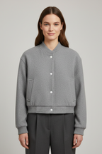 Cropped jacket with snap fastening and ribbed cuffs, product still life