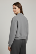 Cropped jacket with snap fastening and ribbed cuffs, product still life