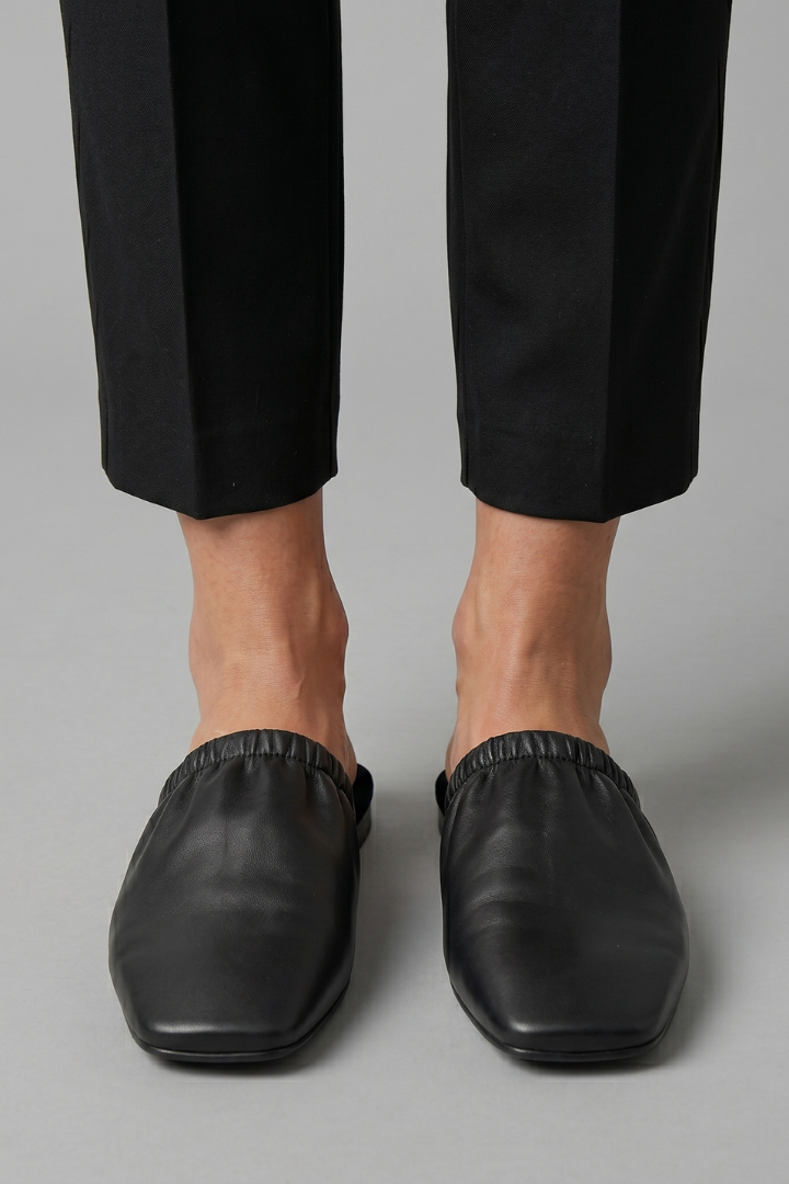 Black leather mules with cap toe and slip-on fit