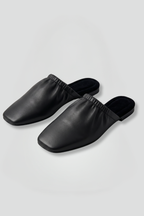 Black leather mules with cap toe and slip-on fit