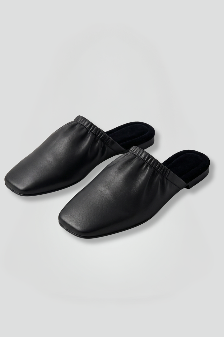 Black leather mules with cap toe and slip-on fit