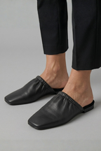 Black leather mules with cap toe and slip-on fit