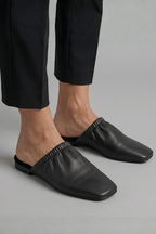 Black leather mules with cap toe and slip-on fit