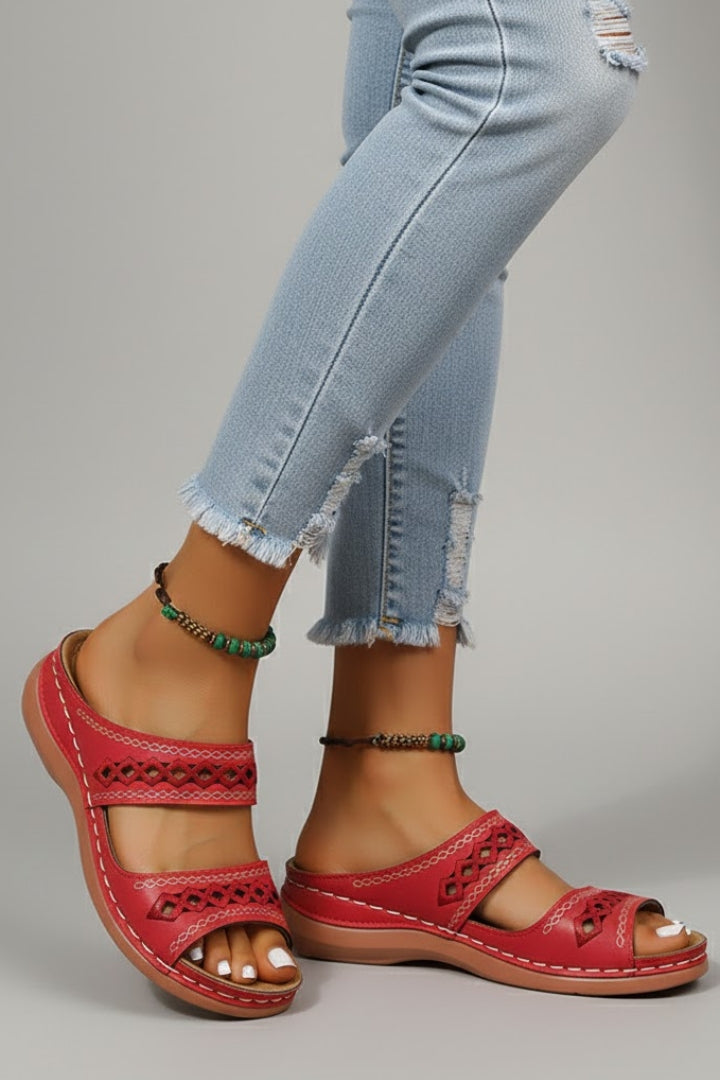 Dual-strap slide sandals with decorative cutouts, product still life