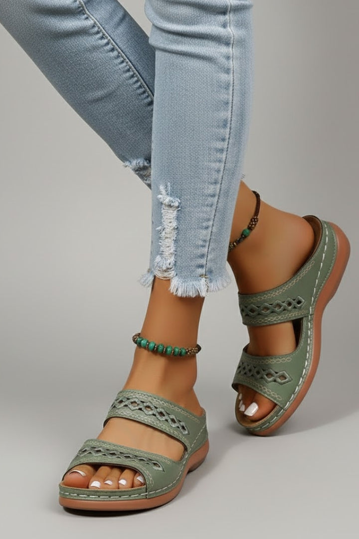 Dual-strap slide sandals with decorative cutouts, product still life