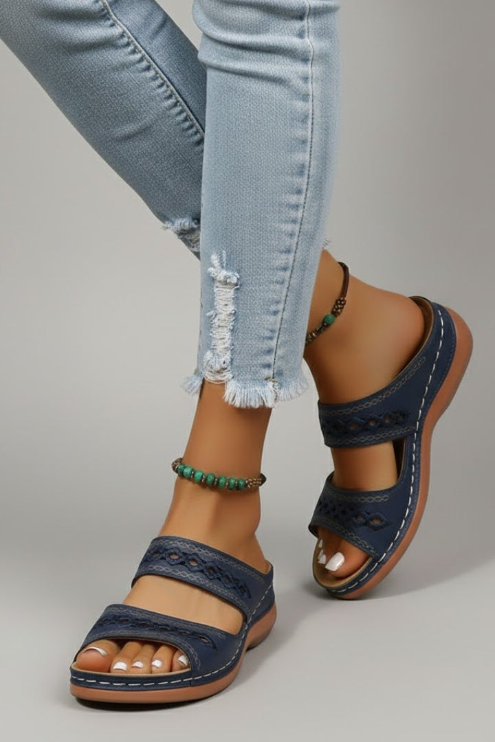 Dual-strap slide sandals with decorative cutouts, product still life
